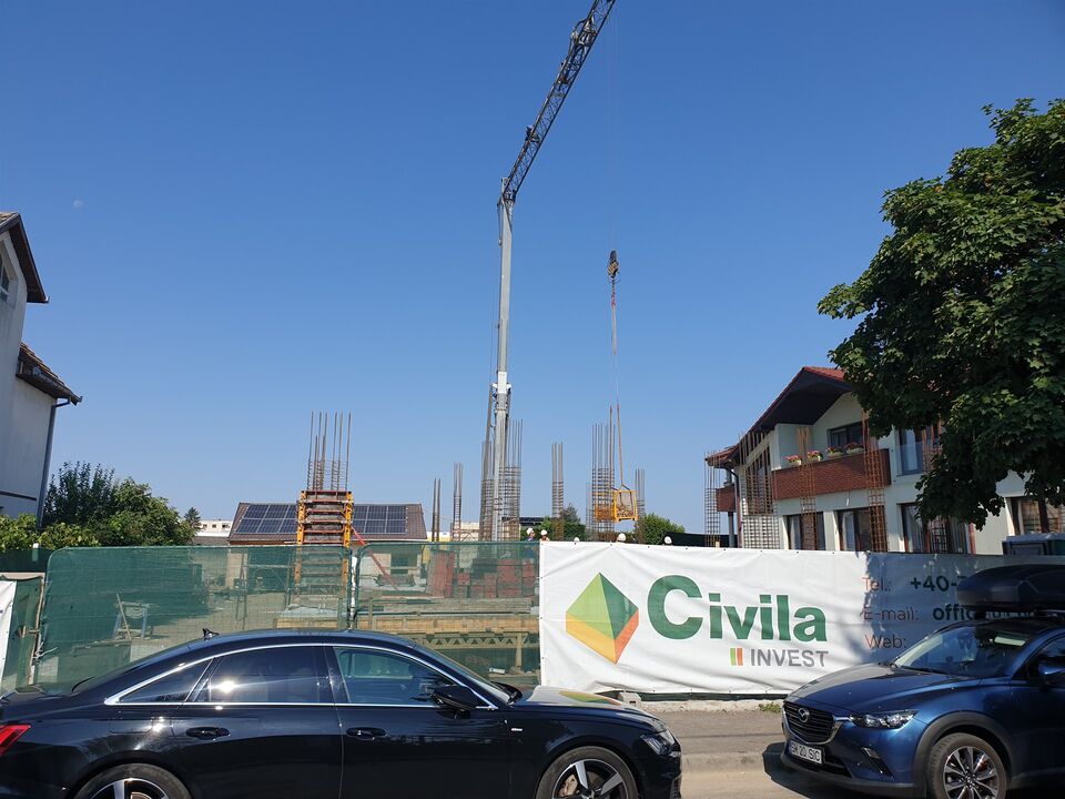 Șantierul clinicii Datcu din Satu Mare, cu bannerul Civila Invest pe împrejmuire și macaraua la lucru