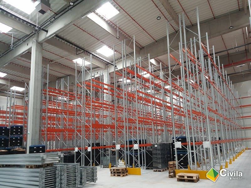 Interiorul centrului logistic KHD din Sibiu — rafturi înalte montate pe pardoseala industrială a halei