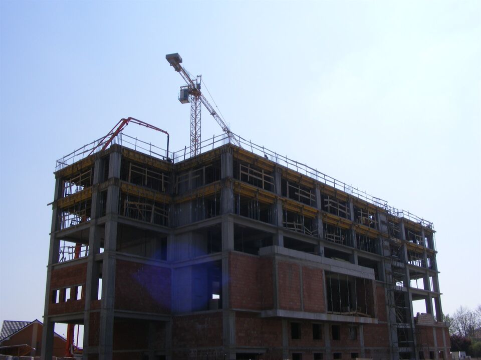 Hotelul Ramada din Oradea în execuție: structura din beton armat cu macaraua turn, pompa de beton pe ultimul planșeu și zidăria din cărămidă la primele niveluri