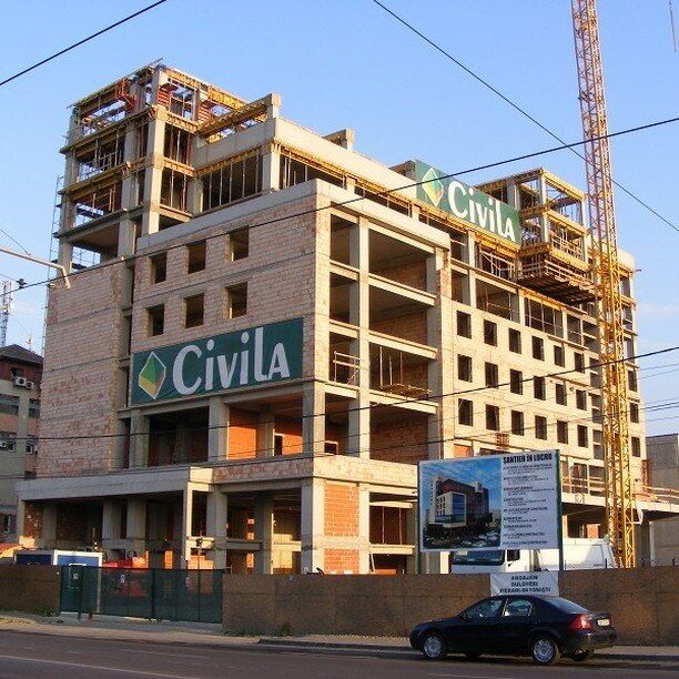 Hotelul Ramada din Oradea în execuție, cu bannerele Civila pe fațadă și macaraua turn lângă clădire