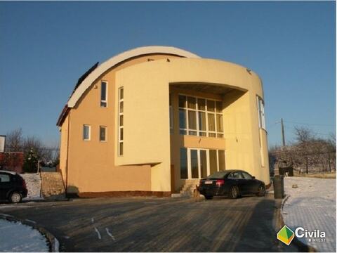 Casa particulară din Oradea (2005): volum galben cu acoperiș curb și ferestre mari, vitrate, la parter și etaj