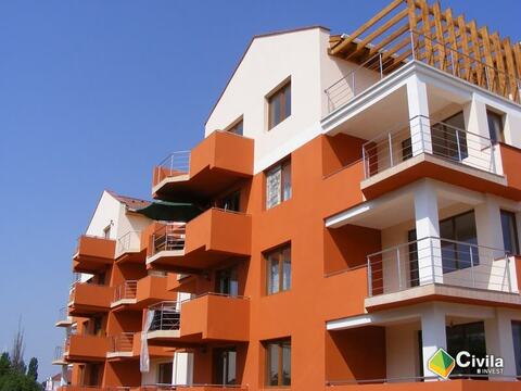 Blocurile din Cartierul Confort văzute din colț, cu balcoanele portocalii în consolă și pergola din lemn de la ultimul nivel