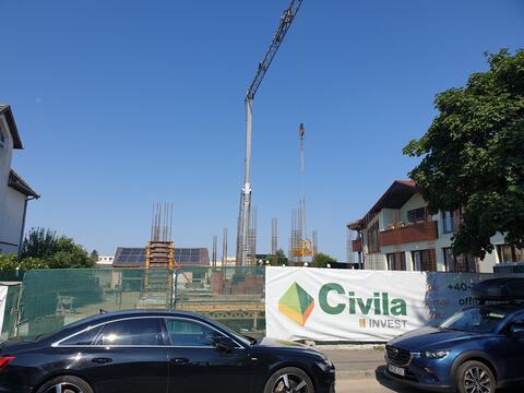 Șantierul clinicii Datcu văzut din stradă, cu bannerul Civila Invest pe împrejmuire și macaraua turn