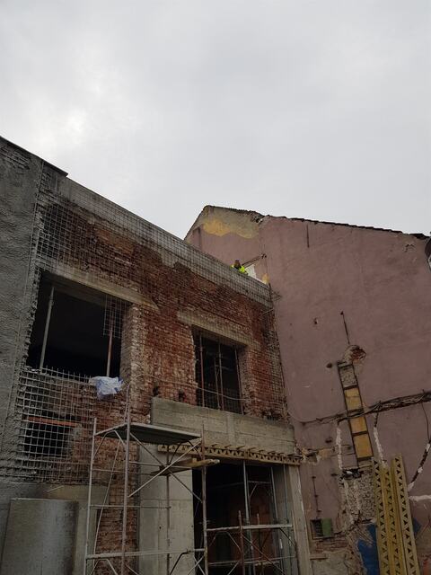 Colțul clădirii Faber, cu pereții de cărămidă armați cu plasă și schelă la golurile de la parter