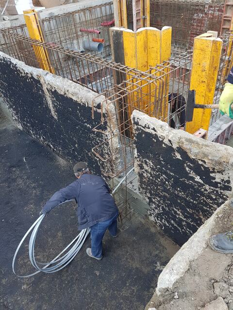 Pereți noi din beton cu hidroizolație bituminoasă pe exterior și cofrajele stâlpilor în lucru