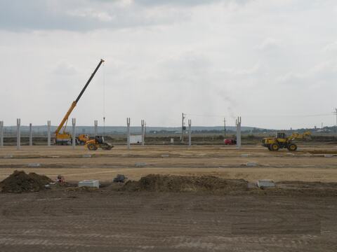 Stâlpii prefabricați ai halei Hanil Electronics montați pe platformă, cu macaraua mobilă, încărcătorul și cilindrul compactor la lucru