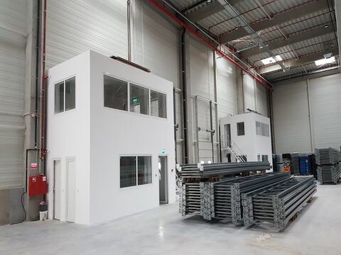 Interiorul halei KHD din Sibiu, cu două birouri și elementele rafturilor pregătite pentru montaj pe pardoseala industrială