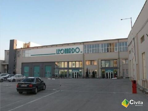 Sediul și depozitul central Leonardo din Oradea: fațada cu firma, trei uși secționale, intrări vitrate și parcarea din față