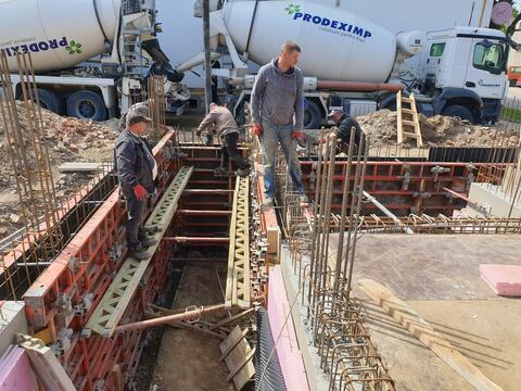 Cofrajele pereților din beton armat la turnare, cu autobetonierele în spate