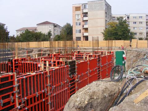 Cofraje metalice pentru pereții infrastructurii, în groapa de fundație a Hotelului Ramada, cu blocurile vecine în fundal