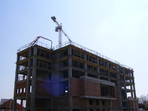 Structura în cadre din beton armat a Hotelului Ramada, ridicată pe mai multe niveluri, cu zidăria de închidere începută jos și pompa de beton la lucru sus