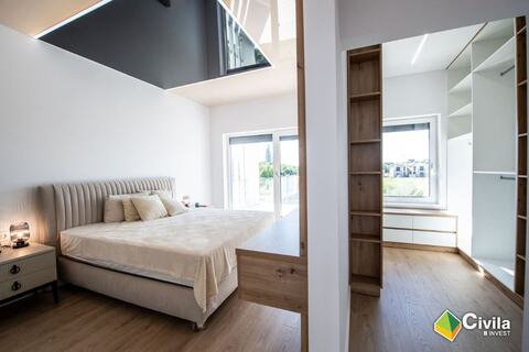 Dormitor într-un duplex din Royal Valley, cu dressing din lemn și ferestre mari