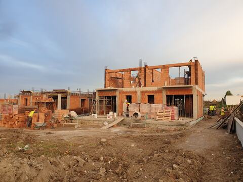 A Royal Valley duplex with the first-floor masonry going up, next to a neighbouring house still at ground-floor level