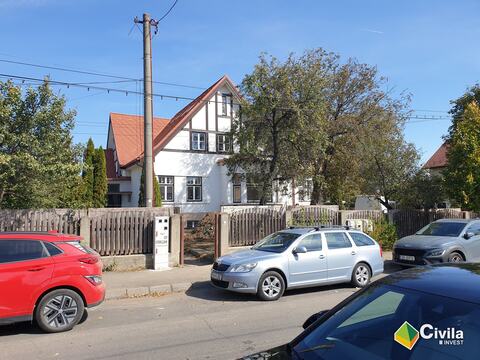 Locuința S+P+M din Sibiu după reabilitare, văzută din stradă, cu fațadele albe și acoperișul nou din țiglă roșie