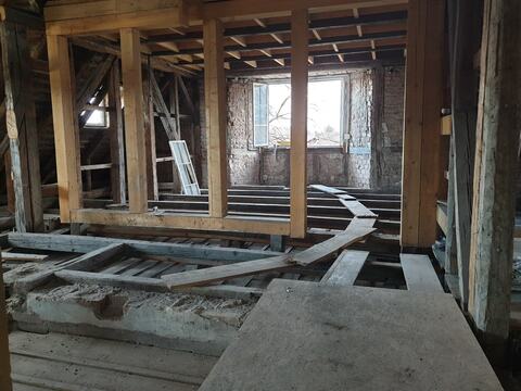 Podul în lucru: stâlpi și grinzi noi din lemn lângă structura veche, cu zidăria de cărămidă la vedere